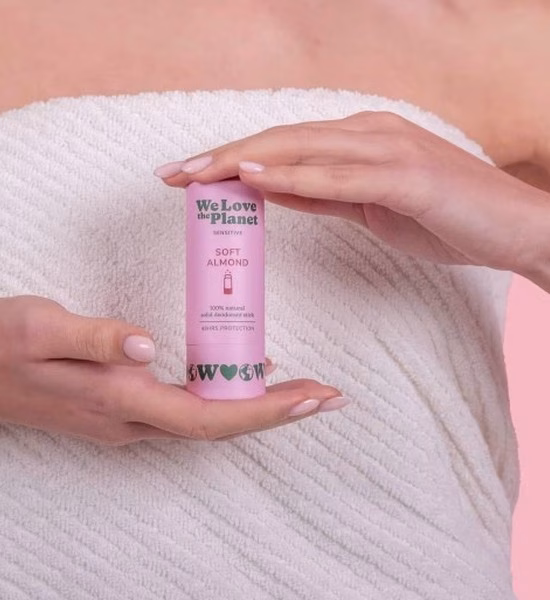 Dłonie trzymające dezodorant w sztyfcie Soft Almond We Love The Planet